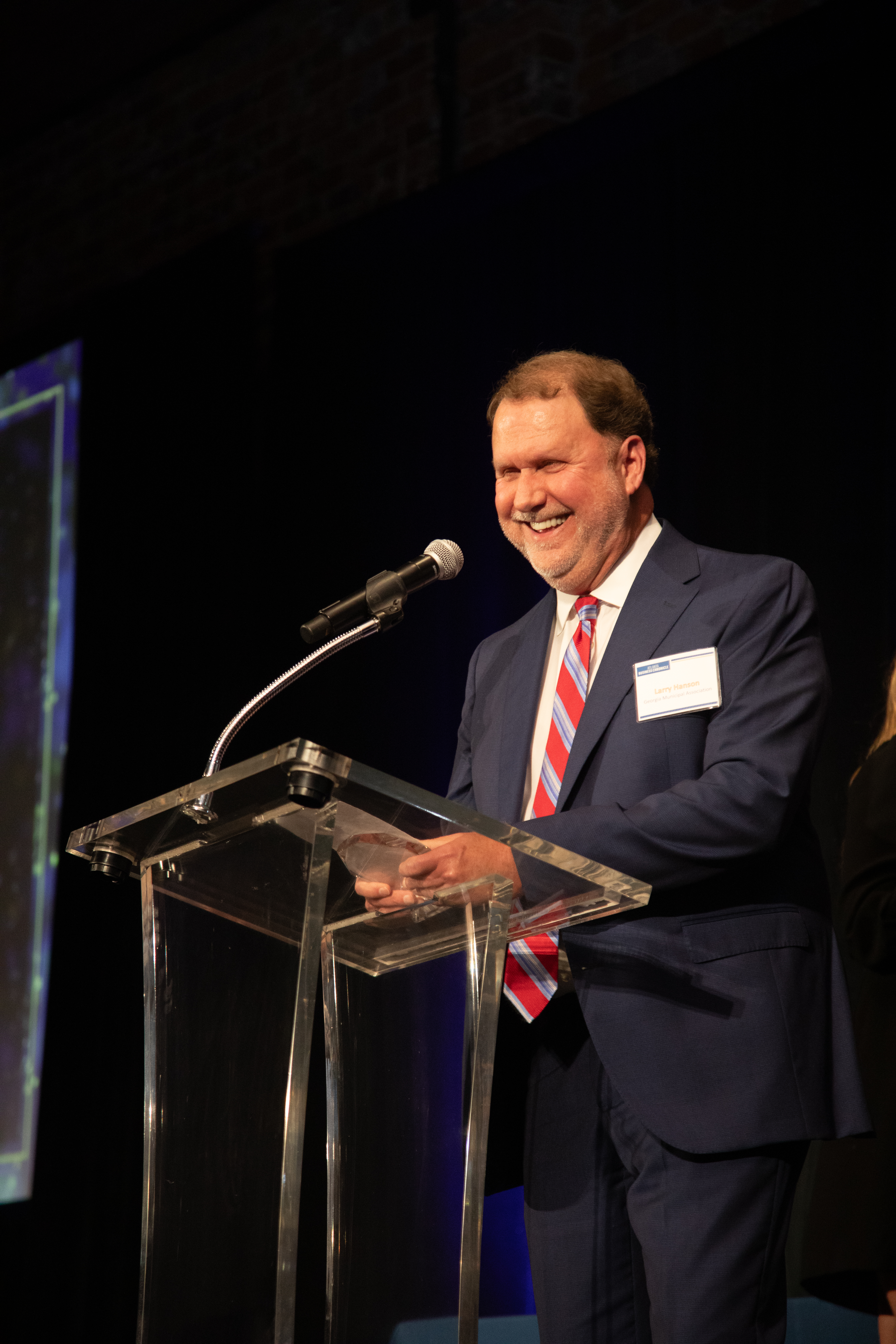 Larry in a suit standing in front of a podium. 