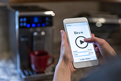 Person brewing coffee through a phone app. 