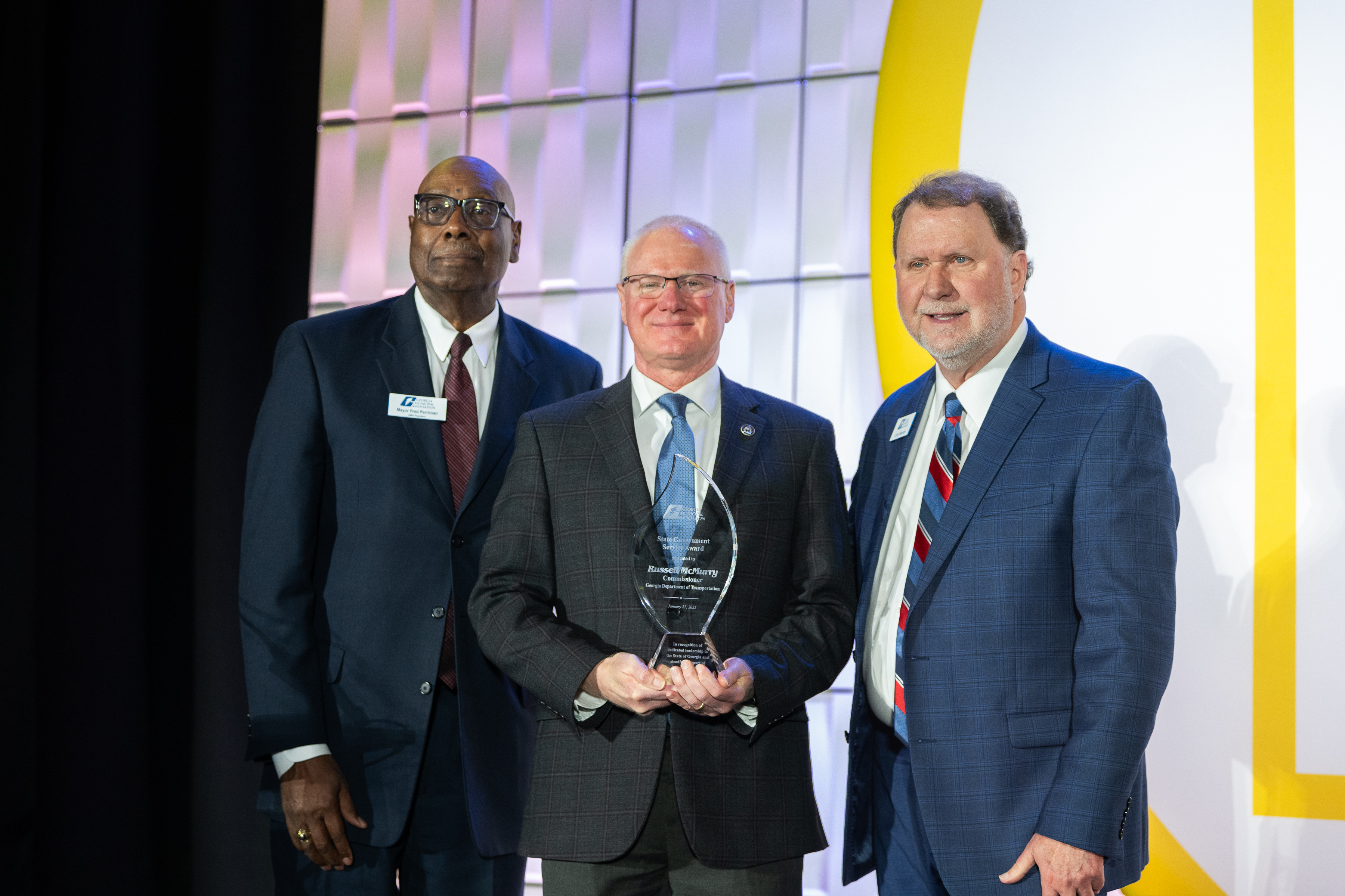 Commissioner Russell McMurry stands with his award with GMA President Fred Perriman and GMA CEO and Executive Director Larry Hanson. 